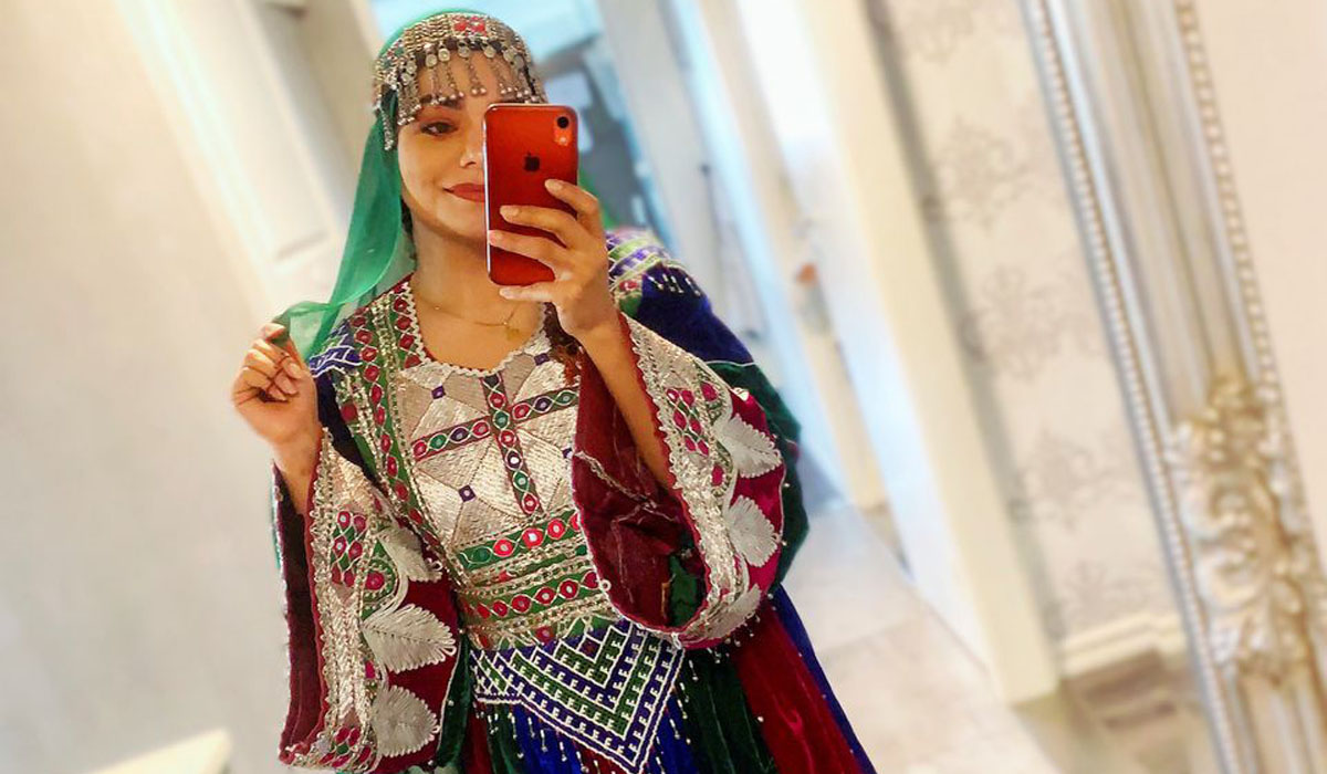 A woman poses in traditional Afghan attire
